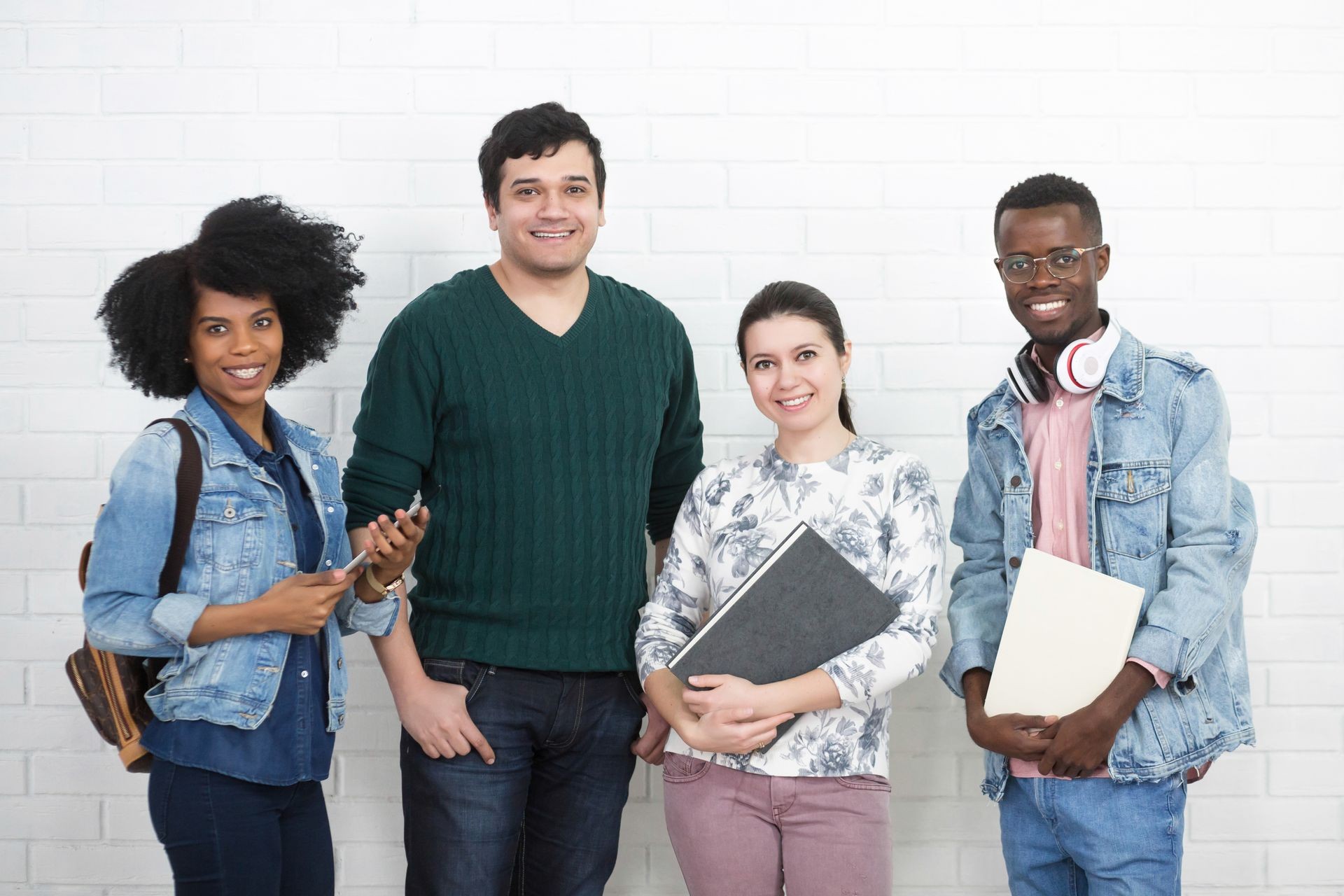 Group of youth adult multiracial college students reading and holding education books in the hands. Knowledge concept on white wall background, full lengths shot Group of youth adult multiracial college students reading and holding education books in the hands. Knowledge concept on white wall background, full lengths shot